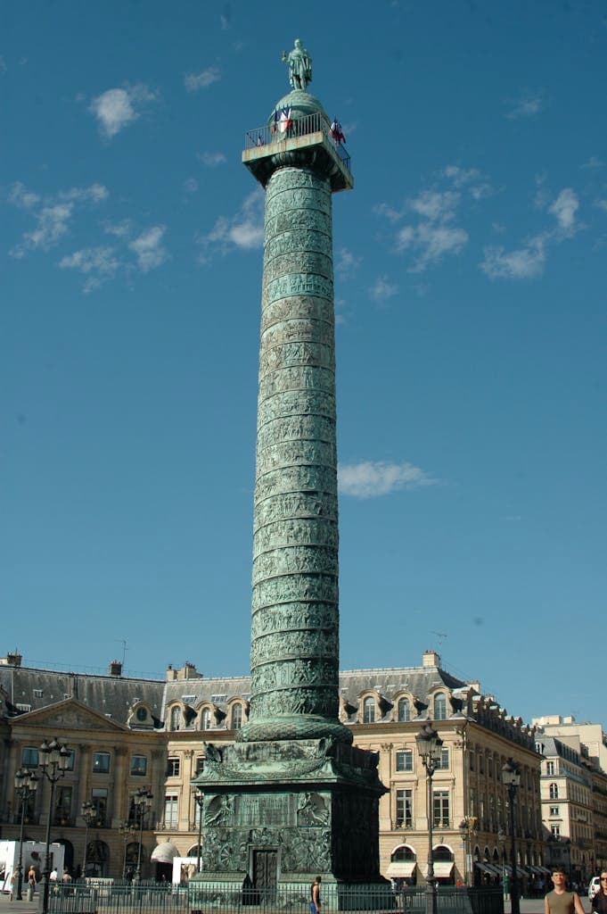 A stunning view of the historic Vendôme Column under a clear blue sky in Paris.