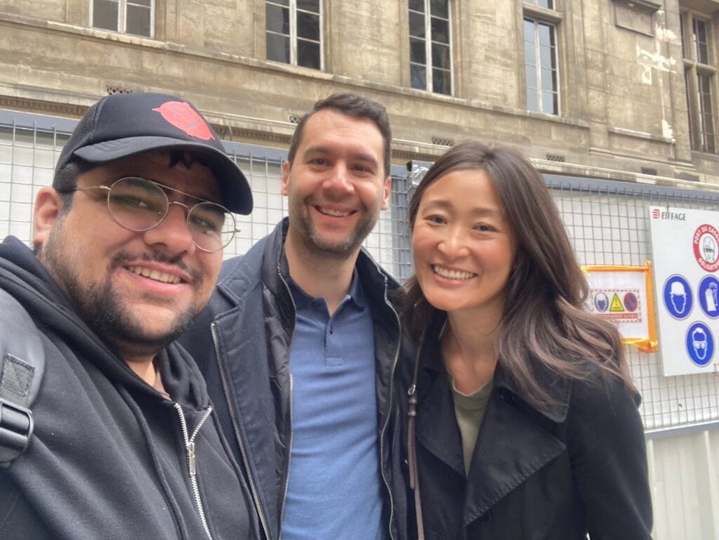 Sz with the Group who took Guided tour A beautifully lit street in Paris, France during the holiday season with festive lights and bustling traffic. Happy guests on Scenic Zest walking tour of Notre Dame Paris Cathedral -gallery